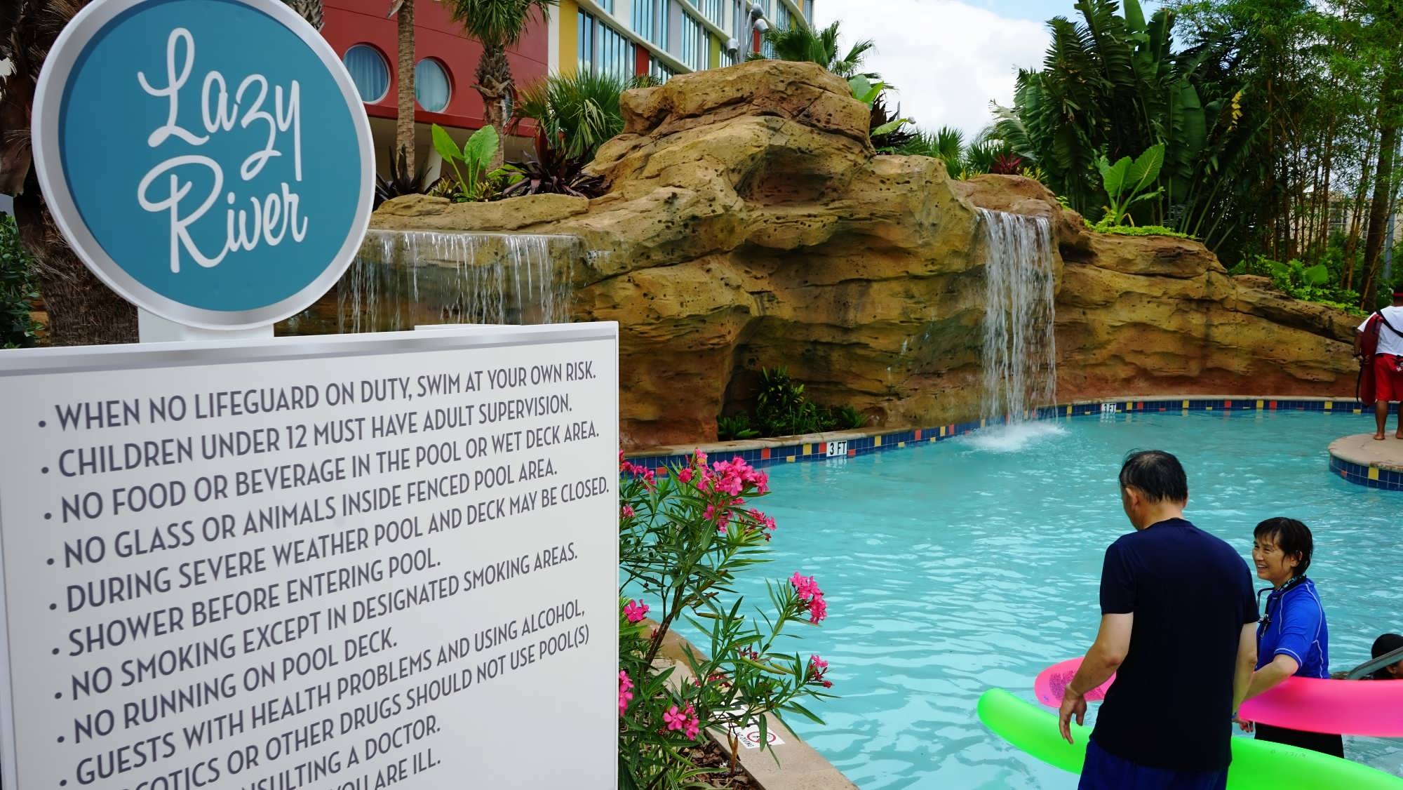 Guests enter the lazy river at Cabana Bay Beach Resort, as waterfalls spill down the rockwork into the river.