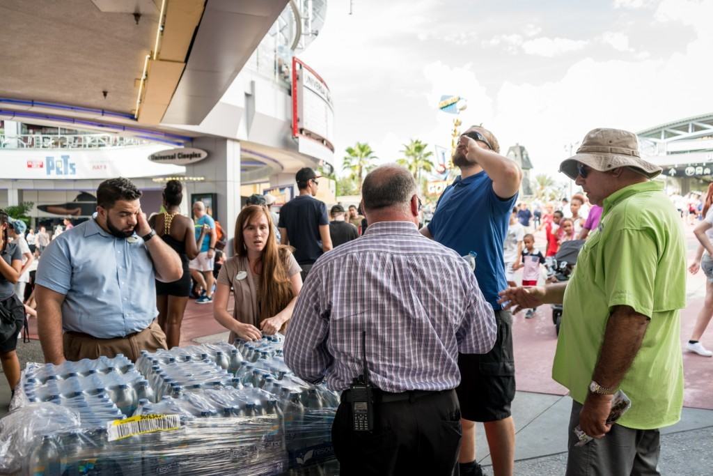 Universal Orlando Team Members distribute bottled water while transportation hub is closed