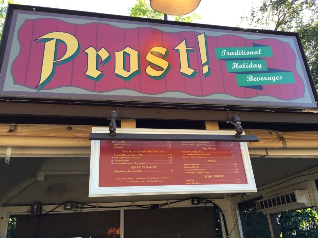 Booth offering holiday treats including fruit cake and caramel kiss beverage.