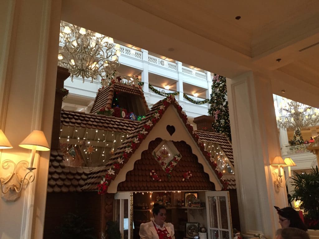 Giant gingerbread house in the Grand Floridian Hotel. Young woman is selling goodies inside.