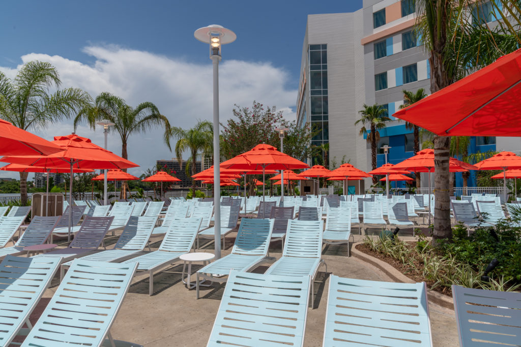 Rows of blue lounge chairs with red sun umbrellas at Surfside Inn and Suites