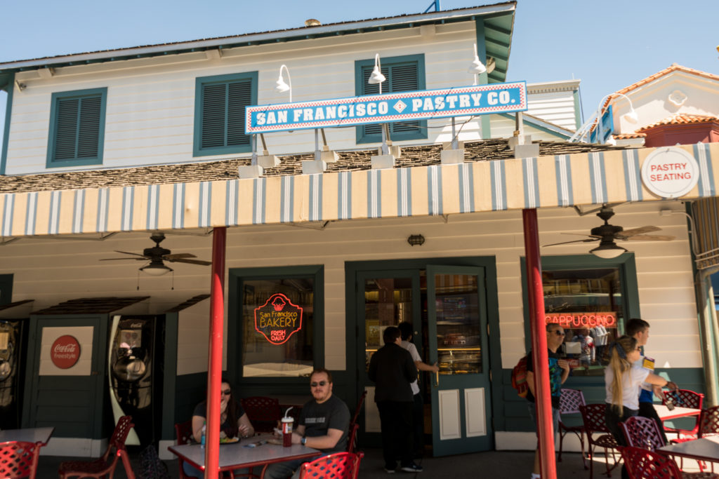 Guests enjoy a pastry at the tables in front of San Francisco Pastry Company at Universal Studios Florida