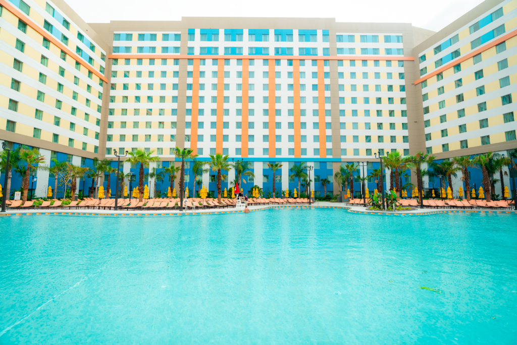 The towers of Dockside Inn and Suites overlook the pool area, surrounded by lounge chairs and palm trees.